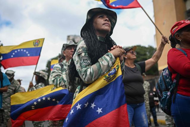 Members of the Bolivarian National Militia take part in a rally to mark the anniversary of the Battle of Santa Ines, in Caracas on December 10, 2025. (Photo by Federico PARRA / AFP)