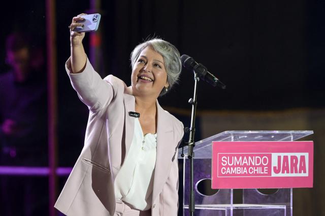 Chile's presidential candidate Jeannette Jara of the Unidad por Chile coalition takes a photo with her mobile phone during her closing campaign rally in Santiago on December 10, 2025. The second round of the Chilean presidential election on December 14 will pit two candidates against each other who are diametrically opposed: Jeannette Jara, the representative of a broad left-wing coalition with modest origins, and the far-right leader Jose Antonio Kast, an ultraconservative Catholic determined to massively expel undocumented migrants. (Photo by Rodrigo ARANGUA / AFP)
