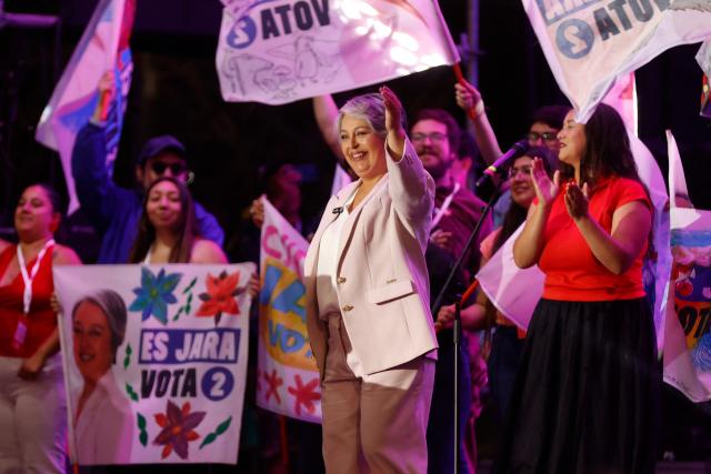Chile's presidential candidate Jeannette Jara (C) of the Unidad por Chile coalition greets supporters during her closing campaign rally in Santiago on December 10, 2025. The second round of the Chilean presidential election on December 14 will pit two candidates against each other who are diametrically opposed: Jeannette Jara, the representative of a broad left-wing coalition with modest origins, and the far-right leader Jose Antonio Kast, an ultraconservative Catholic determined to massively expel undocumented migrants. (Photo by Raul BRAVO / AFP)