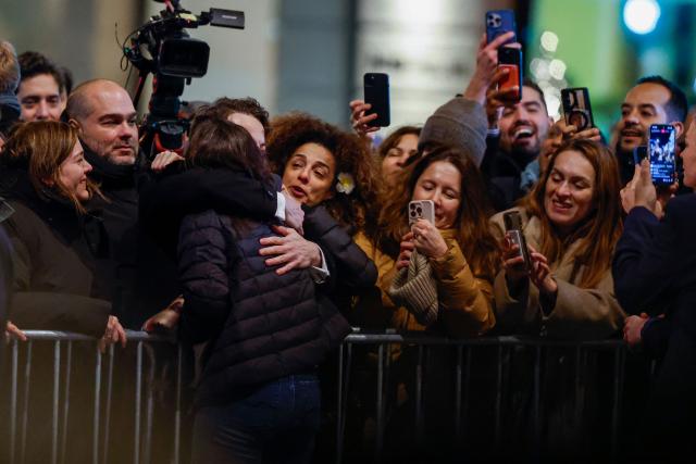 Nobel peace laureate Maria Corina Machado is hugged by supporters gathered outside the Grand Hotel in Oslo, Norway, in the early hours of December 11, 2025. Machado arrived in Oslo hours after the Venezuelan opposition leader's award was collected on her behalf by her daughter. (Photo by Odd ANDERSEN / AFP)