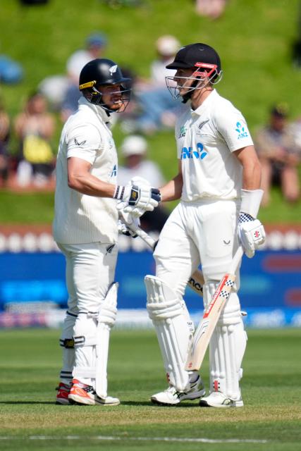 New Zealand's Mitchell Hay (R) celebrates 50 runs with teammate Glenn Phillips during day two of the 2nd international Test cricket match between New Zealand and West Indies at the Basin reserve in Wellington on December 11, 2025. (Photo by Marty MELVILLE / AFP)