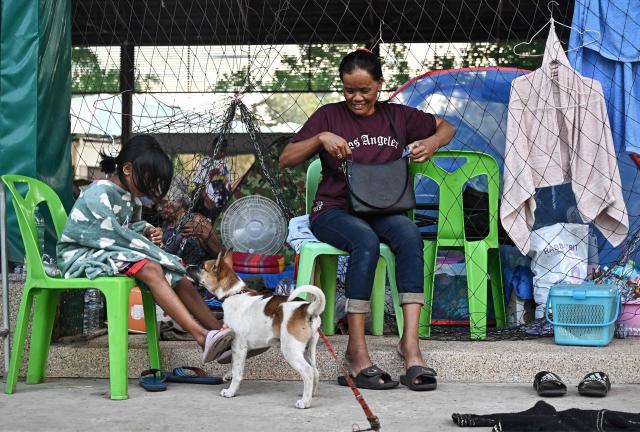 Displaced residents rest at an evacuation center in the Thai border province of Surin on December 11, 2025, during clashes along the Thai-Cambodia border. Renewed fighting raged at the border of Cambodia and Thailand on December 11, with combat heard near centuries-old temples, ahead of an expected phone call from US President Donald Trump to the two nations' leaders. (Photo by Lillian SUWANRUMPHA / AFP)