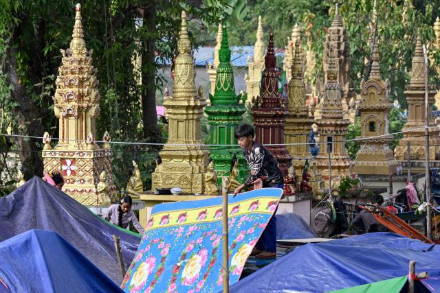 A displaced resident prepares a shelter at a temporary camp set up at a pagoda during clashes along the Cambodia-Thailand border in Cambaodia's Siem Reap province on December 11, 2025. Renewed fighting raged at the border of Cambodia and Thailand on December 11, with combat heard near centuries-old temples, ahead of an expected phone call from US President Donald Trump to the two nations' leaders. (Photo by TANG CHHIN Sothy / AFP)