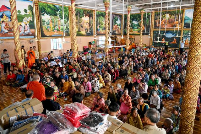 Displaced residents gather to receive aid at a temporary camp set up at a pagoda during clashes along the Cambodia-Thailand border in Cambodia's Siem Reap province on December 11, 2025. Renewed fighting raged at the border of Cambodia and Thailand on December 11, with combat heard near centuries-old temples, ahead of an expected phone call from US President Donald Trump to the two nations' leaders. (Photo by TANG CHHIN Sothy / AFP)