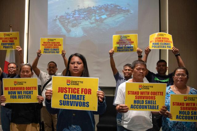Trixy Elle (centre, L), and other survivors of super Typhoon Rai, pose for photos during a press conference at a hotel in Manila on December 11, 2025. Survivors of a deadly 2021 typhoon in the Philippines filed a UK lawsuit against British oil giant Shell, seeking financial compensation for climate-related devastation, three NGOs supporting claimants announced December 11. (Photo by Ted ALJIBE / AFP)