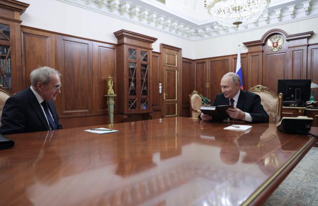 In this pool photograph distributed by the Russian state agency Sputnik, Russia's President Vladimir Putin meets with the Constitutional Court Chairman Valery Zorkin at the Kremlin in Moscow on December 11, 2025. (Photo by Gavriil Grigorov / POOL / AFP)