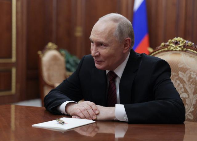 In this pool photograph distributed by the Russian state agency Sputnik, Russia's President Vladimir Putin attends a meeting with the Constitutional Court Chairman at the Kremlin in Moscow on December 11, 2025. (Photo by Gavriil Grigorov / POOL / AFP)