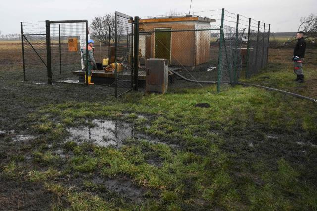 Workers clean up following a leak in an oil pipeline of the PCK refinery in Gramzow, eastern Germany on December 11, 2025. The PCK refinery near the border with Poland is majority-owned by Rosneft Deutschland, a local subsidiary of the Russian oil giant, and managed through a trusteeship by the German government (Photo by RALF HIRSCHBERGER / AFP)