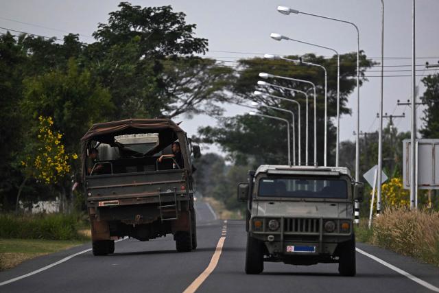 Thai military vehicles are pictured on a road in the Thai border province of Surin on December 11, 2025, amid clashes along the Thai-Cambodia border. Renewed fighting raged at the border of Cambodia and Thailand on December 11, with combat heard near centuries-old temples, ahead of an expected phone call from US President Donald Trump to the two nations' leaders. (Photo by Lillian SUWANRUMPHA / AFP)