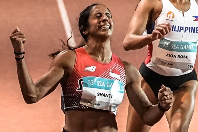 Singapore's Shanti Pereira (L) celebrates as she crosses the finish line in the women's 100m final of the athletics event during the 33rd Southeast Asian Games (SEA Games) at the Suphachalasai National Stadium in Bangkok on December 11, 2025. (Photo by Chanakarn Laosarakham / AFP)