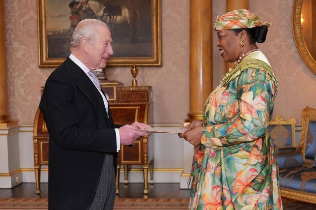 Dominica High Commissioner Loreen Bannis-Roberts (R) presents her credentials to Britain's King Charles III (L) during a private audience at Buckingham Palace in London on December 11, 2025. (Photo by Yui Mok / POOL / AFP)