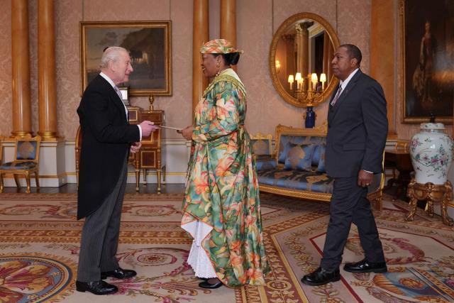 Dominica High Commissioner Loreen Bannis-Roberts (C), accompanied by her husband McDonald Roberts (R), presents her credentials to Britain's King Charles III (L) during a private audience at Buckingham Palace in London on December 11, 2025. (Photo by Yui Mok / POOL / AFP)