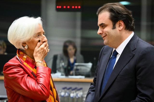 European Central Bank (ECB) President Christine Lagarde (L) reacts as she speaks with candidate for the Eurogroup Presidency, Greece's Economy and Finance Minister Kyriakos Pierrakakis (R) at the start of a meeting with finance ministers of the Eurozone to elect the new Eurogroup President and discuss the overall budgetary situation and the prospects of euro area, at the European Commission, in Brussels, on December 11, 2025. (Photo by NICOLAS TUCAT / AFP)