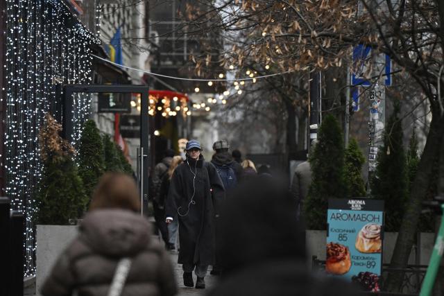Pedestrians walk past Christmas lights displayed on a street in central Kyiv on December 11, 2025, amid the Russian invasion of Ukraine. (Photo by Genya SAVILOV / AFP)