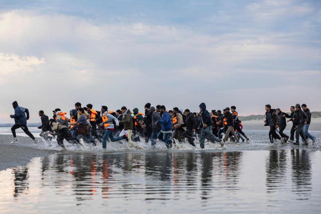 AFP PICTURES OF THE YEAR 2025

Migrants run to board a smuggler's boat in an attempt to cross the English Channel off the beach of Gravelines, northern France on August 12, 2025. (Photo by Sameer Al-DOUMY / AFP) / AFP PICTURES OF THE YEAR 2025