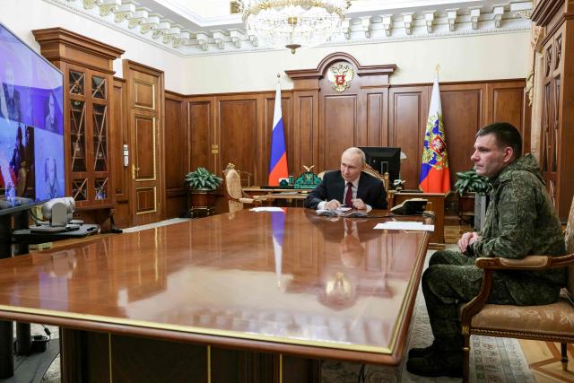 In this pool photograph distributed by Russian state agency Sputnik, Russia's President Vladimir Putin (L) and Commander of the 123rd Motorised Rifle Brigade Denis Pirogov (R) take part in a meeting regarding the situation in the area of the so-called "special military operation" in Ukraine with Russian military officials via video link in Moscow on December 11, 2025. Russia said on December 11, 2025 its troops had seized full control of Siversk, a Ukrainian city in the eastern Donetsk region, one of the key settlements where fighting has intensified in recent weeks. (Photo by Gavriil GRIGOROV / POOL / AFP)