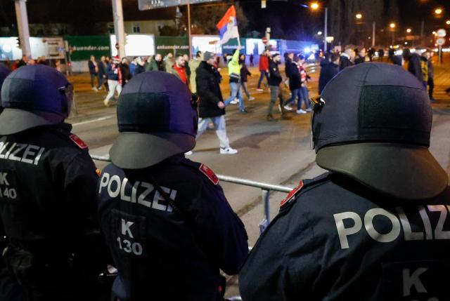 Riot police observe as the fans of Red Star Belgrade make their way to the stadium prior to the UEFA Europa League football match between SK Sturm Graz and Crvena Zvezda (Red Star Belgrade) in Graz, Austria on December 11, 2025. (Photo by ERWIN SCHERIAU / APA / AFP) / Austria OUT