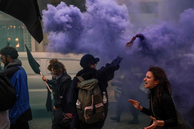 TOPSHOT - Protestors take part in a demonstration during a general strike against a labour code reform project, called by the country's two main unions in Lisbon on December 11, 2025. Widespread disruption hit Portuguese air travel and trains, hospitals and schools as the unions called the biggest nationwide strike action for more than a decade, protesting against a draft law aiming to simplify firing procedures, extend the length of fixed-term contracts and expand the minimum services required during a strike. (Photo by PATRICIA DE MELO MOREIRA / AFP)
