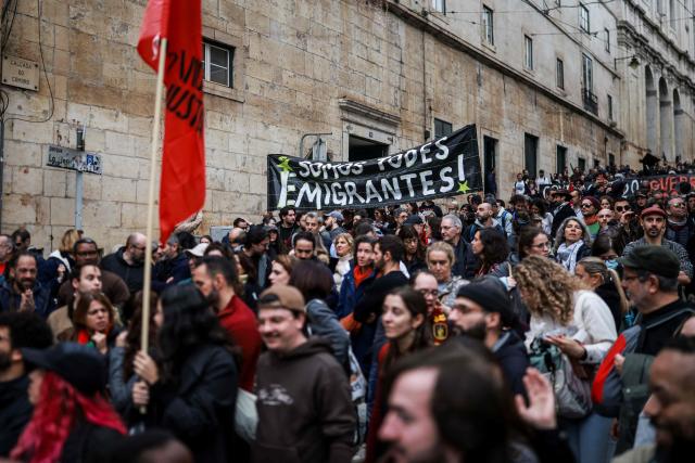 Protestors hold a banner reading 'We are all migrants' while demonstrating during a general strike against a labour code reform project, called by the country's two main unions in Lisbon on December 11, 2025. Widespread disruption hit Portuguese air travel and trains, hospitals and schools as the unions called the biggest nationwide strike action for more than a decade, protesting against a draft law aiming to simplify firing procedures, extend the length of fixed-term contracts and expand the minimum services required during a strike. (Photo by PATRICIA DE MELO MOREIRA / AFP)