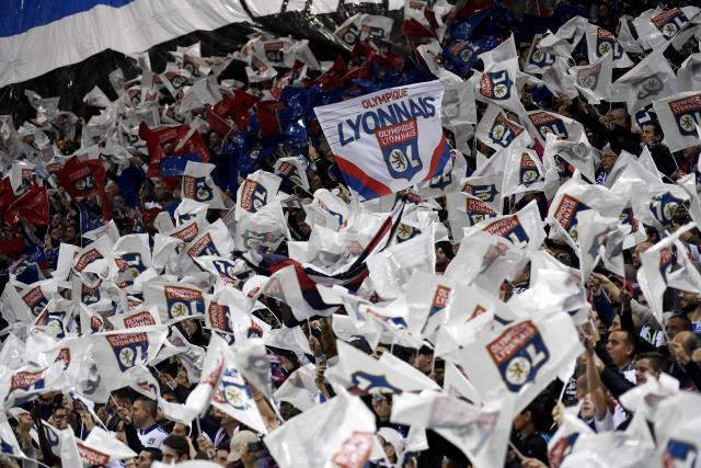 (FILES) Olympique Lyonnais' fans wave flags with the logo of the club during the French L1 football match between Olympique Lyonnais (OL) and AS Saint-Etienne (ASSE) at the Parc Olympique Lyonnais stadium in Decines-Charpieu near Lyon, southeastern France, on October 2, 2016. Olympique Lyonnais will be subject to payroll expenditure restrictions and strict supervision of its recruitment in the next transfer window, imposed by the DNCG of the Professional Football League (Ligue de Football Professionnel) it was announced on December 11, 2025. (Photo by PHILIPPE DESMAZES / AFP)