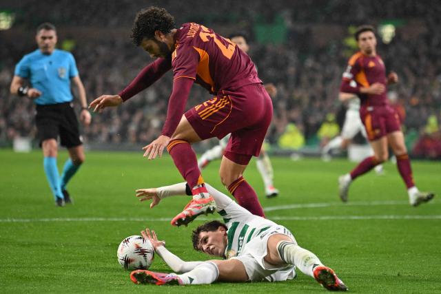 Celtic's Belgian midfielder #27 Arne Engels (bottom) is brought down by Roma's Spanish defender #22 Mario Hermoso (top) for Celtic to earn a penalty during the UEFA Europa League league stage football match between Celtic and Roma at Celtic Park in Glasgow on December 11, 2025. (Photo by ANDY BUCHANAN / AFP)