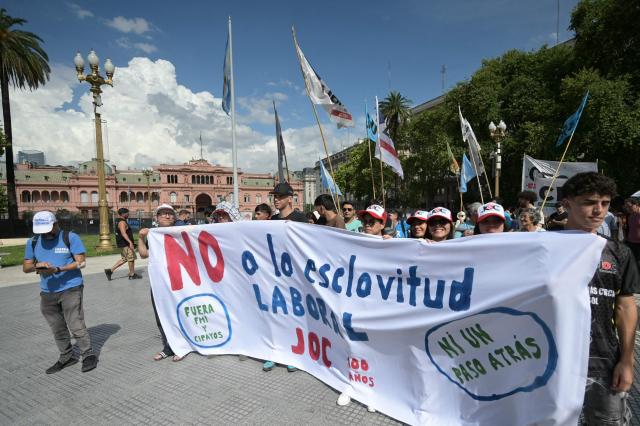 People holding a flag against the labor reform promoted by Argentina’s President Javier Milei take part in the Resistant March called by human rights organization Madres de Plaza de Mayo, at Plaza de Mayo square in Buenos Aires on December 11, 2025. (Photo by JUAN MABROMATA / AFP)