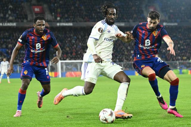 Aston Villa's Ivorian forward #29 Evann Guessand (C) fights for the ball with Basel's Swiss midfielder #31 Dominik Schmid (R) during the UEFA Europa League, league phase, football match between FC Basel and Aston Villa at the St Jakob-Park stadium, in Basel, on December 11, 2025. (Photo by SEBASTIEN BOZON / AFP)