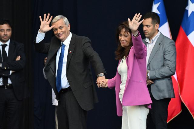 Chile's presidential candidate Jose Antonio Kast of the Republican Party waves to supporters next to his wife Maria Adriasola during his closing campaign rally in Temuco, Chile on December 11, 2025. The second round of the Chilean presidential election on December 14 will pit two candidates against each other who are diametrically opposed: Jeannette Jara, the representative of a broad left-wing coalition with modest origins, and the far-right leader Jose Antonio Kast, an ultraconservative Catholic determined to massively expel undocumented migrants. (Photo by Eitan ABRAMOVICH / AFP)