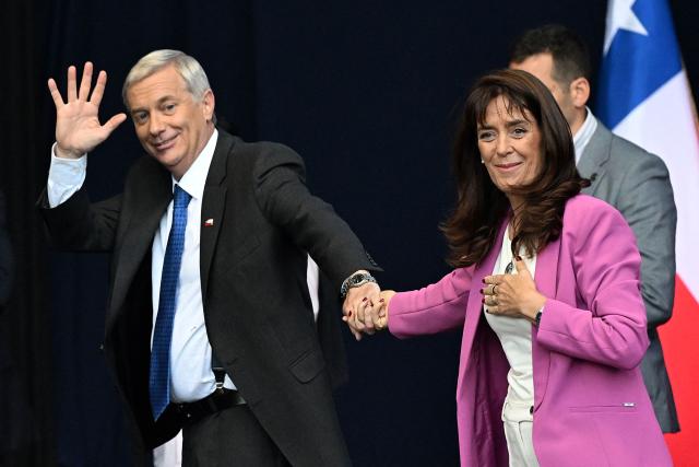 Chile's presidential candidate Jose Antonio Kast of the Republican Party waves to supporters next to his wife Maria Adriasola during his closing campaign rally in Temuco, Chile on December 11, 2025. The second round of the Chilean presidential election on December 14 will pit two candidates against each other who are diametrically opposed: Jeannette Jara, the representative of a broad left-wing coalition with modest origins, and the far-right leader Jose Antonio Kast, an ultraconservative Catholic determined to massively expel undocumented migrants. (Photo by Eitan ABRAMOVICH / AFP)