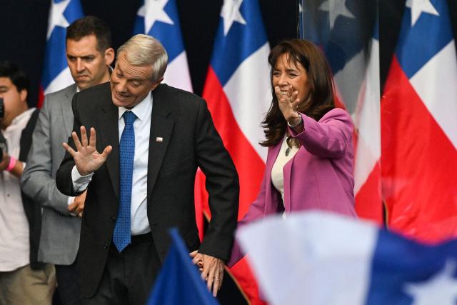 Chile's presidential candidate Jose Antonio Kast of the Republican Party waves to supporters next to his wife Maria Adriasola during his closing campaign rally in Temuco, Chile on December 11, 2025. The second round of the Chilean presidential election on December 14 will pit two candidates against each other who are diametrically opposed: Jeannette Jara, the representative of a broad left-wing coalition with modest origins, and the far-right leader Jose Antonio Kast, an ultraconservative Catholic determined to massively expel undocumented migrants. (Photo by Eitan ABRAMOVICH / AFP)