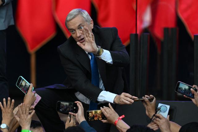Chile's presidential candidate Jose Antonio Kast of the Republican Party waves to supporters during his closing campaign rally in Temuco, Chile on December 11, 2025. The second round of the Chilean presidential election on December 14 will pit two candidates against each other who are diametrically opposed: Jeannette Jara, the representative of a broad left-wing coalition with modest origins, and the far-right leader Jose Antonio Kast, an ultraconservative Catholic determined to massively expel undocumented migrants. (Photo by EITAN ABRAMOVICH / AFP)