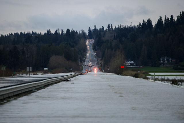 Flood waters from the Snohomish River cover a portion of State Route 9 in Snohomish, Washington, on December 11, 2025. Tens of thousands of people were under evacuation orders Thursday in western North America, after days of heavy rain forced rivers to burst their banks. Storms have battered Washington state in the US and British Columbia over the Canadian border for several days, with rivers continuing to rise. (Photo by Jason Redmond / AFP)