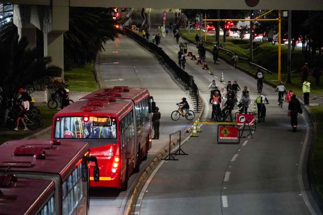 People ride bicycles during a car free night cycle way as part of Christmas celebrations in Bogota on December 11, 2025 (Photo by Sergio Angel / AFP)