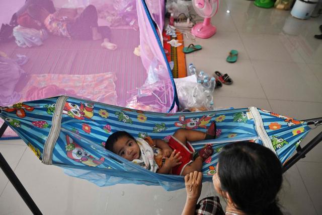 Displaced residents rest at an evacuation center in the Thai border province of Surin on December 12, 2025. At least 20 people have been killed in the latest round of border fighting that reignited last week, officials said. (Photo by Lillian SUWANRUMPHA / AFP)