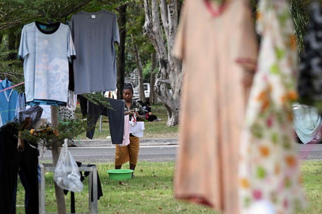 Displaced residents hang clothes at an evacuation center in the Thai border province of Surin on December 12, 2025. At least 20 people have been killed in the latest round of border fighting that reignited last week, officials said. (Photo by Lillian SUWANRUMPHA / AFP)