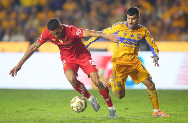 Toluca's Uruguayan defender #06 Federico Pereira and Tigres' Argentine forward #07 Angel Correa fight for the ball during the Liga MX Apertura final first leg football match between Tigres and Toluca at the UANL University Stadium in San Nicolas de los Garza, Nuevo Leon State, Mexico on December 11, 2025. (Photo by Julio Cesar AGUILAR / AFP)