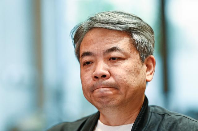 In this picture taken on December 10, 2025, Jiang Hui, whose mother was on board the missing Malaysia Airlines flight MH370, is seen during an interview with AFP at his home in Beijing. When Jiang Hui thinks of his mother, he remembers her waving goodbye as she left for her Malaysia Airlines flight, a bag slung across her shoulder and promising to return with souvenirs from her trip. Jiang Cuiyun, then a 72-year-old retiree, was one of 239 people aboard flight MH370 when it vanished from radar screens on March 8, 2014, en route from Kuala Lumpur to Beijing. (Photo by Pedro PARDO / AFP) / TO GO WITH AFP STORY:  China-Malaysia-aviation-accident, by Isabel Kua