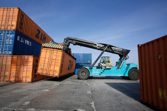 A cargo lifter moves a container for loading onto cars of a freight train at the railway station of Dostyk at the Kazakh-Chinese border, a key hub for trade between China and Europe through Central Asia, on November 19, 2025. (Photo by Ruslan PRYANIKOV / AFP)
