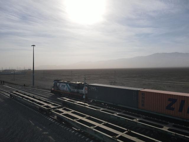 A freight train loaded with cargo containers is seen in the steppe near the railway station of Dostyk at the Kazakh-Chinese border, a key hub for trade between China and Europe through Central Asia, on November 19, 2025. (Photo by Ruslan PRYANIKOV / AFP)