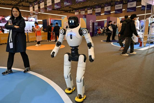 A remote-controlled bipedal humanoid robot by Zhiyuan Robot is seen at the Global Developer Pioneers Summit in Shanghai on December 12, 2025. (Photo by Hector RETAMAL / AFP)