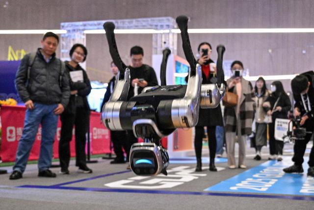 A remote-controlled robot jumps at the Global Developer Pioneers Summit in Shanghai on December 12, 2025. (Photo by Hector RETAMAL / AFP)