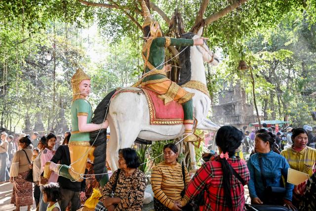 Displaced residents gather to receive aid at a temporary camp set up in a pagoda in Cambodia's Siem Reap province on December 12, 2025, amid clashes along the Cambodia-Thailand border.  (Photo by TANG CHHIN Sothy / AFP)
