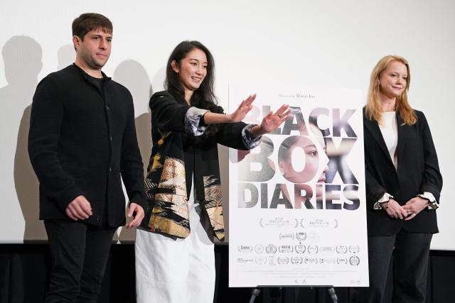 Journalist and Director Shiori Ito (C), Producers Eric Nyari (L) and Hanna Aqvilin (R), pose at a photo session during a stage greeting for the first day of the Japanese release of the feature film "Black Box Diaries" in Tokyo on December 12, 2025. (Photo by Kazuhiro NOGI / AFP)