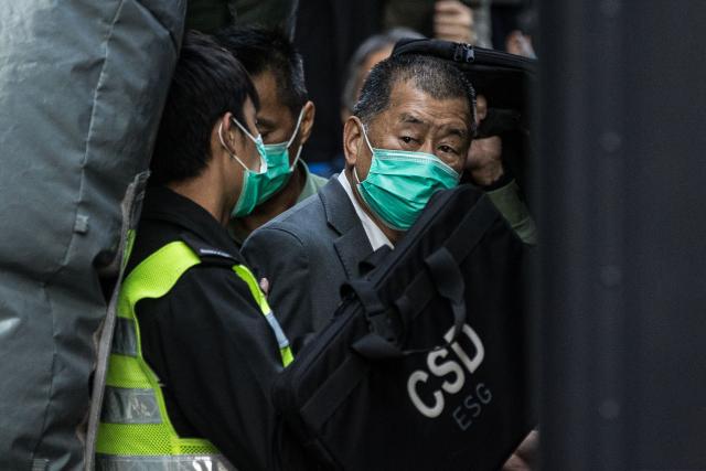 (FILES) Media tycoon Jimmy Lai (R) is escorted into a Hong Kong Correctional Services van outside the Court of Final Appeal in Hong Kong on February 1, 2021, after being ordered to remain in jail while judges consider his fresh bail application, the first major legal challenge to a sweeping national security law Beijing imposed on the city last year. A Hong Kong court will issue a verdict on December 15, 2025 in the national security trial of pro-democracy media tycoon Jimmy Lai, a case widely criticised as a sign of erosion of political freedoms in the Chinese city. (Photo by AFP)