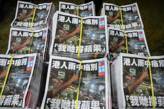 (FILES) Copies of the last Apple Daily newspaper are seen stacked in Hong Kong early on June 24, 2021. A Hong Kong court will issue a verdict on December 15, 2025 in the national security trial of pro-democracy media tycoon Jimmy Lai, a case widely criticised as a sign of erosion of political freedoms in the Chinese city. (Photo by Anthony WALLACE / AFP)