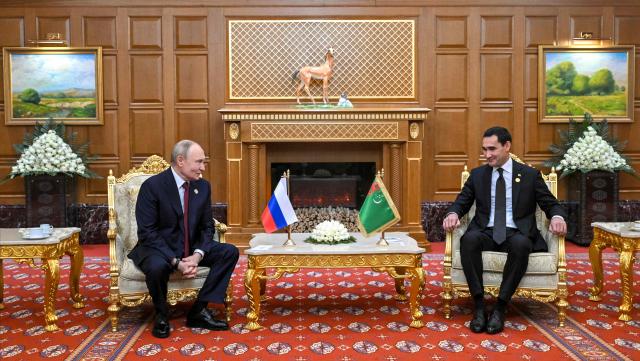 In this pool photograph distributed by the Russian state agency Sputnik, Russia's President Vladimir Putin and Turkmen President Serdar Berdymukhamedov hold a meeting in Ashgabat on December 12, 2025. (Photo by Kristina Kormilitsyna / POOL / AFP)
