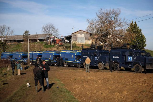 French gendarmerie Centaure multipurpose intervention vehicles and other vehicles are stationed at the entrance of a farm affected by lumpy skin disease (LSD) in Les-Bordes-sur-Arize, in the Ariege department of southwestern France, on December 12, 2025. French riot police took control of the farm by using tear gas, on late evening of December 11 following protests by several hundred farmers since December 10, 2025 to oppose the euthanasia of the 207 cattle and block access to veterinary services. (Photo by Valentine CHAPUIS / AFP)