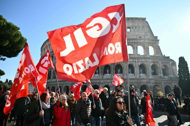 People march near the Colosseum during a national day of strike by Italian union "Confederazione Generale Italiana del Lavoro" (CGIL) against the government's budget law, on December 12, 2025. (Photo by Alberto PIZZOLI / AFP)
