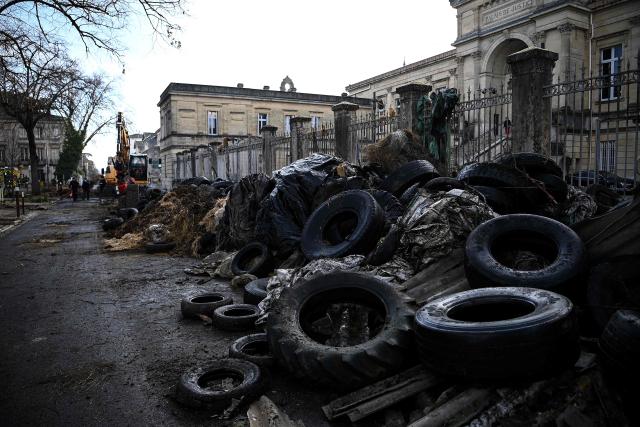 Municipal workers clear debris dumped overnight by farmers of the CR47 union (Coordination rurale 47) in front of the courthouse as part of a protest in Agen, south-western France, on December 12, 2025. (Photo by Christophe ARCHAMBAULT / AFP)