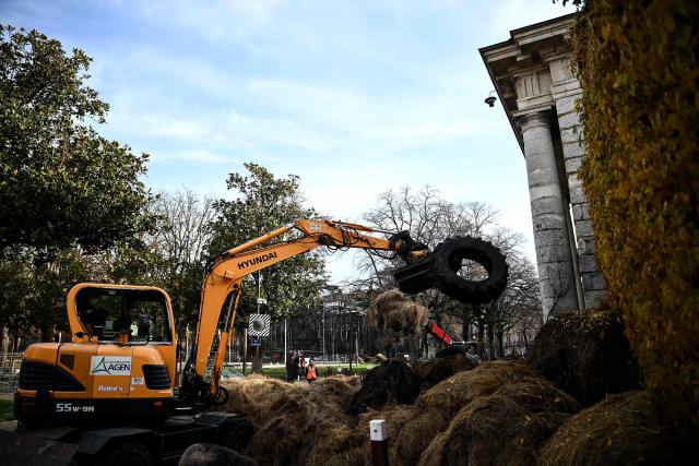 Municipal workers clear debris dumped overnight by farmers of the CR47 union (Coordination rurale 47) in front of the courthouse as part of a protest in Agen, south-western France, on December 12, 2025. (Photo by Christophe ARCHAMBAULT / AFP)